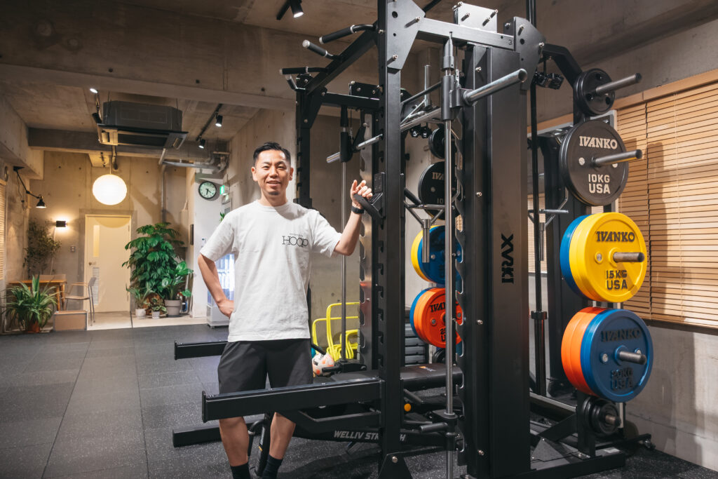 PRIVATE GYM HOOPのトレーナーが、ジム内で笑顔で立っている様子