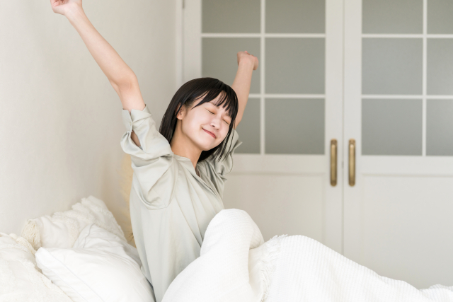朝の光が差し込む部屋で、すっきり目覚めたビジネスパーソン
