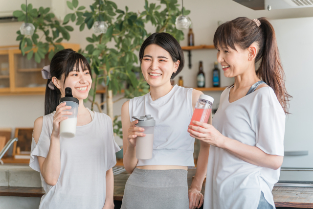 運動のあとに、プロテインなどのドリンクを手に笑顔で話す女性たち