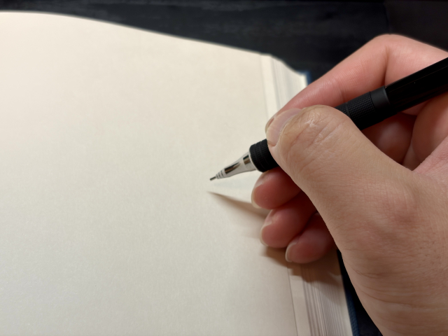ノートにペンで目標を書き込んでいる手元