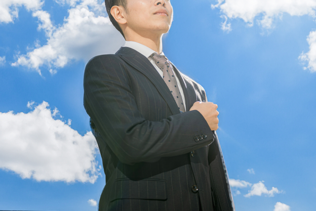 空を見上げるビジネスパーソン