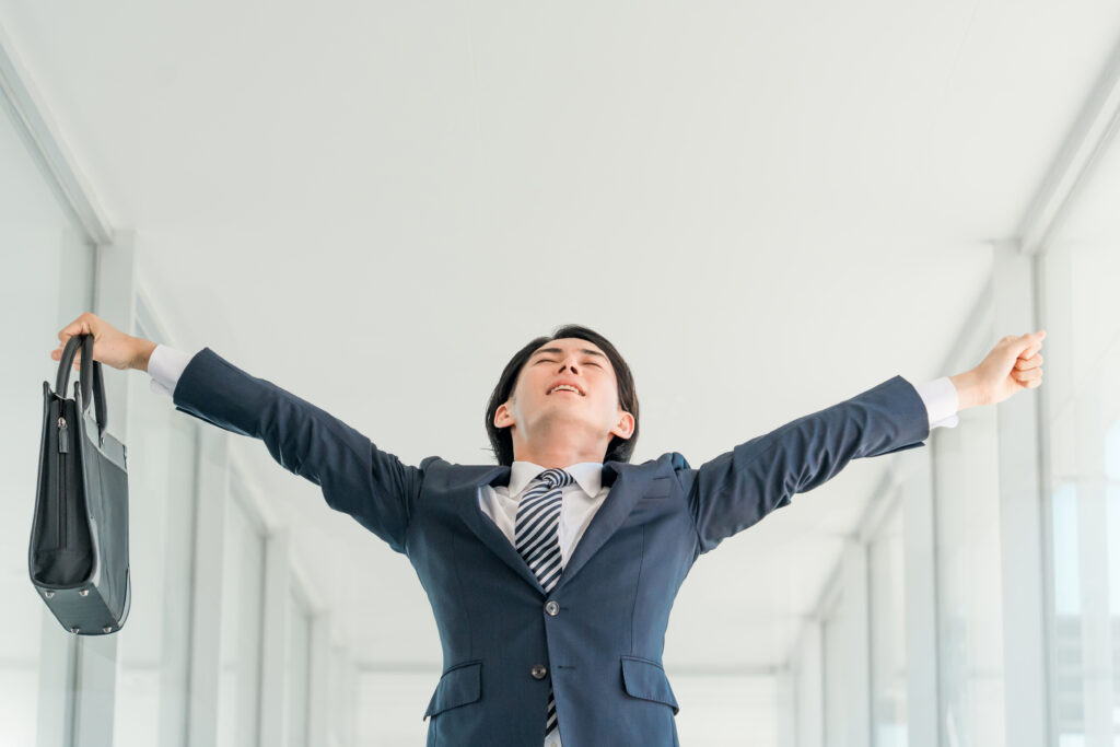 仕事の合間に立ち上がって伸びをする会社員
